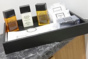 a black shelf with three bottles of soap and boxes at The Ferry House Inn in Plymouth