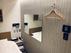 a mirror on a wall in a room with a bed at Takahashi Building 3rd and 4th floors - Vacation STAY 25198v in Musashino
