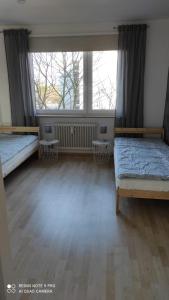 Zimmer mit 2 Betten und einem großen Fenster in der Unterkunft Schöne und gemütliche Wohnung in Bremen