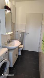 ein Badezimmer mit einem weißen Waschbecken und einem WC in der Unterkunft Schöne und gemütliche Wohnung in Bremen