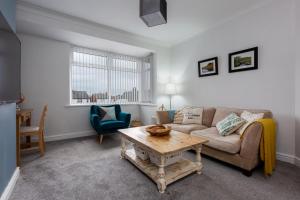 ein Wohnzimmer mit einem Sofa und einem Tisch in der Unterkunft Hillside House - 2 Bedrooms parking WI-FI Hospital in Blackpool