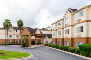 a large apartment building with a parking lot at Red Roof Inn PLUS+ & Suites Savannah – I-95 in Savannah