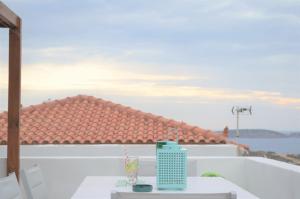 a table on a balcony with a view of a roof at Afroditi's Terrace View in Batsi