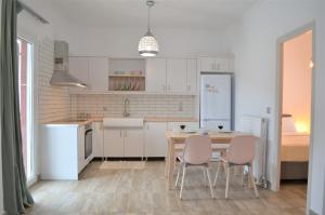 a kitchen with a table and chairs and a bed at Afroditi's Terrace View in Batsi