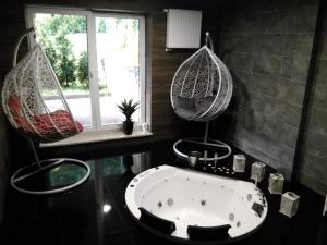 łazienka z wanną i 2 wiszącymi hamakami w obiekcie Kurort Kozubnik Apartament 33 Wellness &SPA w mieście Porąbka +37 zdjęć