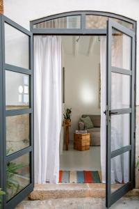 una puerta de cristal abierta que conduce a una sala de estar en Ecocirer Guest House, en Sóller