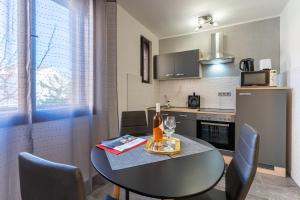 a kitchen with a table and chairs and a kitchen with a counter at Apartment Brđanović in Cres