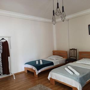 um quarto com 2 camas e um lustre em Leila's Guest House em Joqolo
