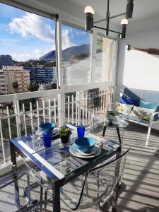 una mesa de cristal con cuencos azules en el balcón en Maite Beach Vibe, en Benalmádena