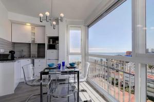 cocina con mesa y sillas y ventana grande en Maite Beach Vibe, en Benalmádena
