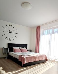 a bedroom with a bed with a clock on the wall at Rubin in Mrzeżyno