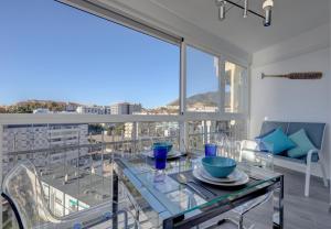 comedor con mesa de cristal en el balcón en Maite Beach Vibe, en Benalmádena