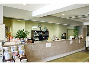 two people sitting at a counter in a store at Central Hotel Toride - Vacation STAY 09920v in Toride +4 photos