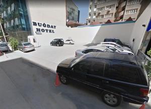 a black suv parked in front of a parking lot at Bugday Hotel in Ankara