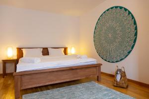 a bedroom with a bed and a large picture on the wall at Stone Way Apartment in Sibiu