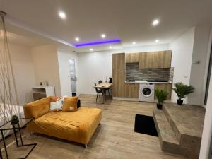 a living room with a couch and a table at Appartement Luxe Jaune in Saint Etienne