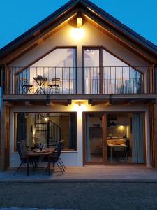 a house with a balcony and a wooden table at BEe in foREST in Pivka