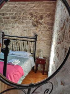 a mirror reflection of a bed in a stone wall at Lilibeth Houses - Charming & Lovely views in Scicli