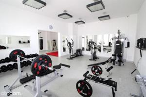 een fitnessruimte met diverse fitnessapparatuur in een kamer bij Apartament Szprotka in Ustronie Morskie
