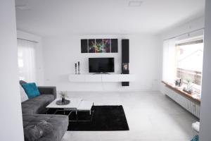 a white living room with a couch and a tv at Ferienwohnung Panoramablick-Rhön in Sandberg