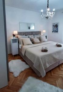 a bedroom with a large bed and a chandelier at Apartman Miletic in Mostar