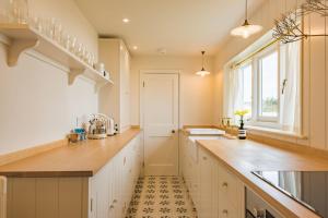a kitchen with a counter and a sink and a window at West Cottage by Bloom Stays in Dungeness
