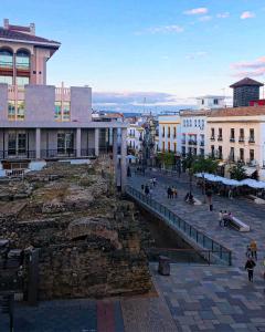 um grupo de pessoas andando em torno de uma cidade com edifícios em Apartamento Templo Romano em Córdoba