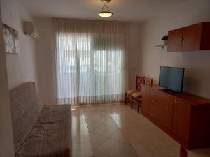 a living room with a couch and a television at Práctico apartamento en el Centro de Marina D´or in Oropesa del Mar
