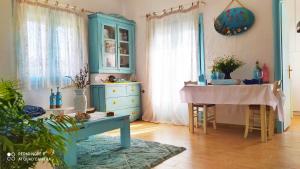 un soggiorno con armadio blu e tavolo di Socrates sea view a Kámpos