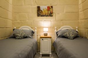 ŻabbarにあるTa' Ġilard - Lovely Renovated Holiday Homeのベッド2台が隣同士に設置された部屋です。