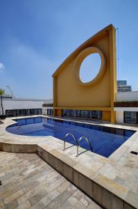 a swimming pool with a circular window on a building at Slaviero São Paulo Ibirapuera in São Paulo