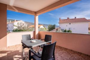 a patio with a table and chairs on a balcony at Apartment Brđanović in Cres