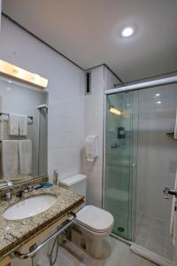 a bathroom with a toilet and a glass shower at Slaviero São Paulo Ibirapuera in São Paulo