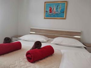un lit avec deux serviettes rouges dessus dans l'établissement One-Bedroom Apartment in Vinisce I, à Vinišće