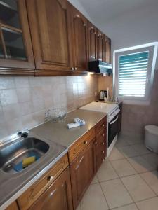une cuisine avec des armoires en bois et un évier dans l'établissement One-Bedroom Apartment in Vinisce I, à Vinišće