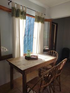 a wooden table and chairs in a room with a window at El puesto in Lobos