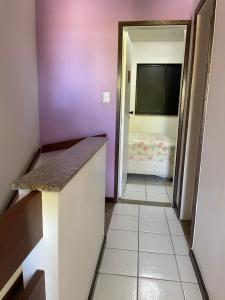 a room with purple walls and a hallway with a bed at Casa em Stella Maris - cond. frente mar in Salvador