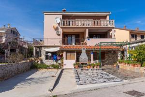 a house with a balcony on top of it at Apartment Brđanović in Cres