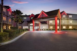 un grand bâtiment avec des lumières rouges dans un parking dans l'établissement Red Roof Inn PLUS+ & Suites Savannah – I-95, à Savannah