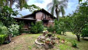 a house with a bunch of plants in front of it at Recanto das Águias - Caminhos de Caravaggio in Nova Petrópolis