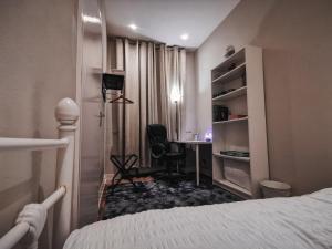 una camera da letto con un letto e una scrivania con una sedia di LUXURIOUS 3 BEDROOM APARTMENT: HEART OF WESTEND a Glasgow