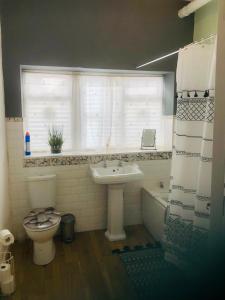 a bathroom with a sink and a toilet and a window at Pierview Place in Weston-super-Mare