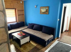 a blue living room with a couch and a table at Apartman Tanja in Kopaonik