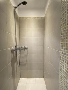 bagno con box doccia e pavimento piastrellato. di Lovely apartment in the heart of Athens ad Atene