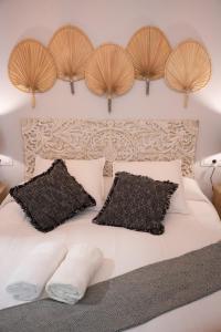 - une chambre avec un lit blanc et des têtes de lit en bois dans l'établissement Apartamento Alma Sevilla, à Séville