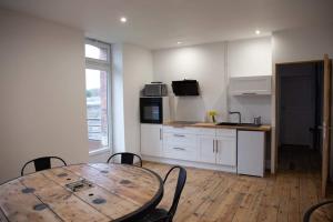 a kitchen with a wooden table and a wooden floor at CYRIS - Chambres Duplex climatisées - Spa & Piscine Centre ville in Saint-Germain-des-Fossés