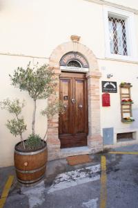 a building with a wooden door with a tree in front at Affittacamere Carnevali MJ in Loreto