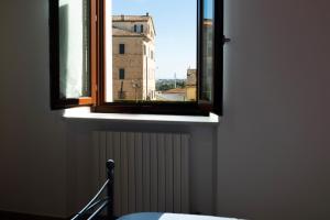 une fenêtre avec vue sur un bâtiment dans l'établissement Affittacamere Carnevali MJ, à Loreto