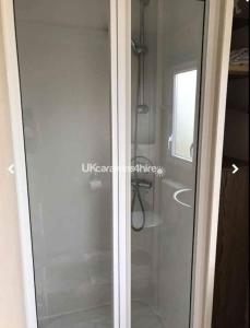 a glass shower door in a bathroom at Caravan Primrose Valley WW in Hunmanby