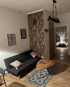 a living room with a black couch and a table at Casa Di Carla in Canino